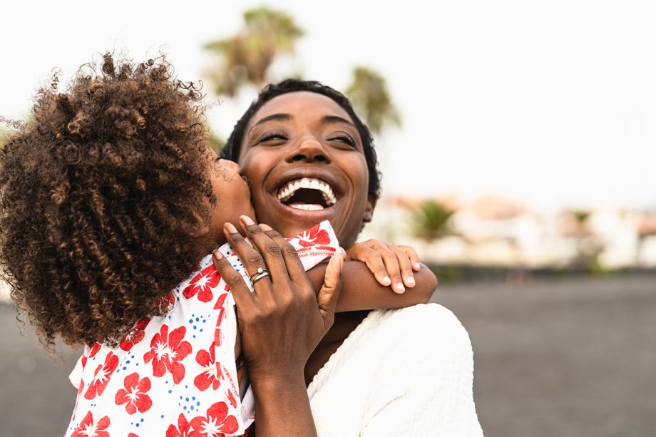 child kisses laughing adult