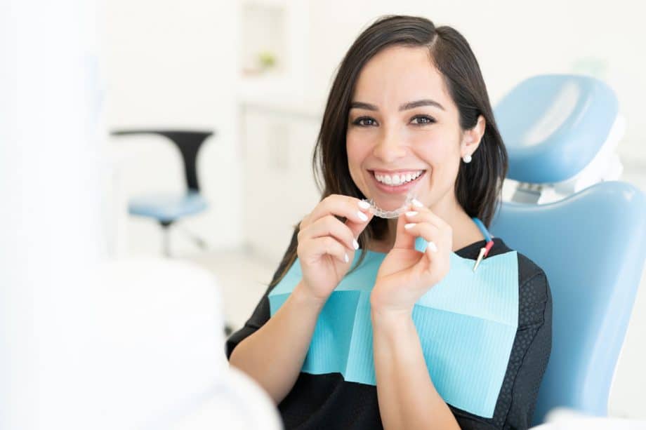woman in dental chair with Invisalign aligner